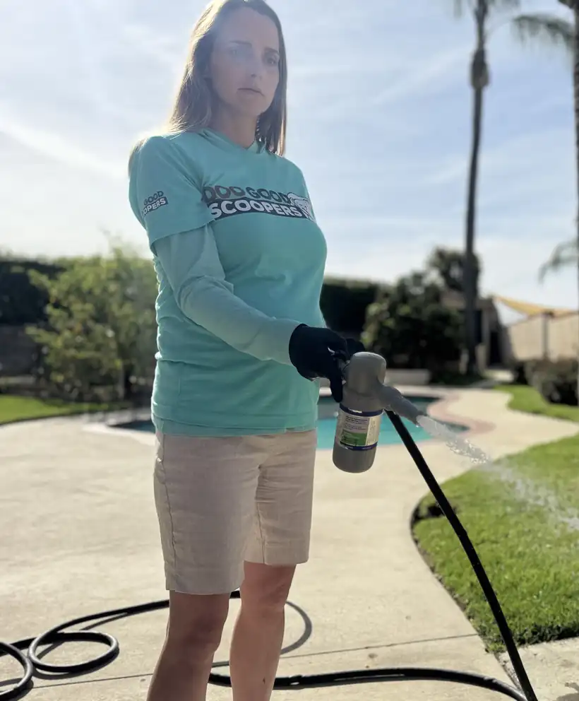 Scoop Doggy Logs technician spraying FRESHguard sanitizer on an Inland Empire turf yard